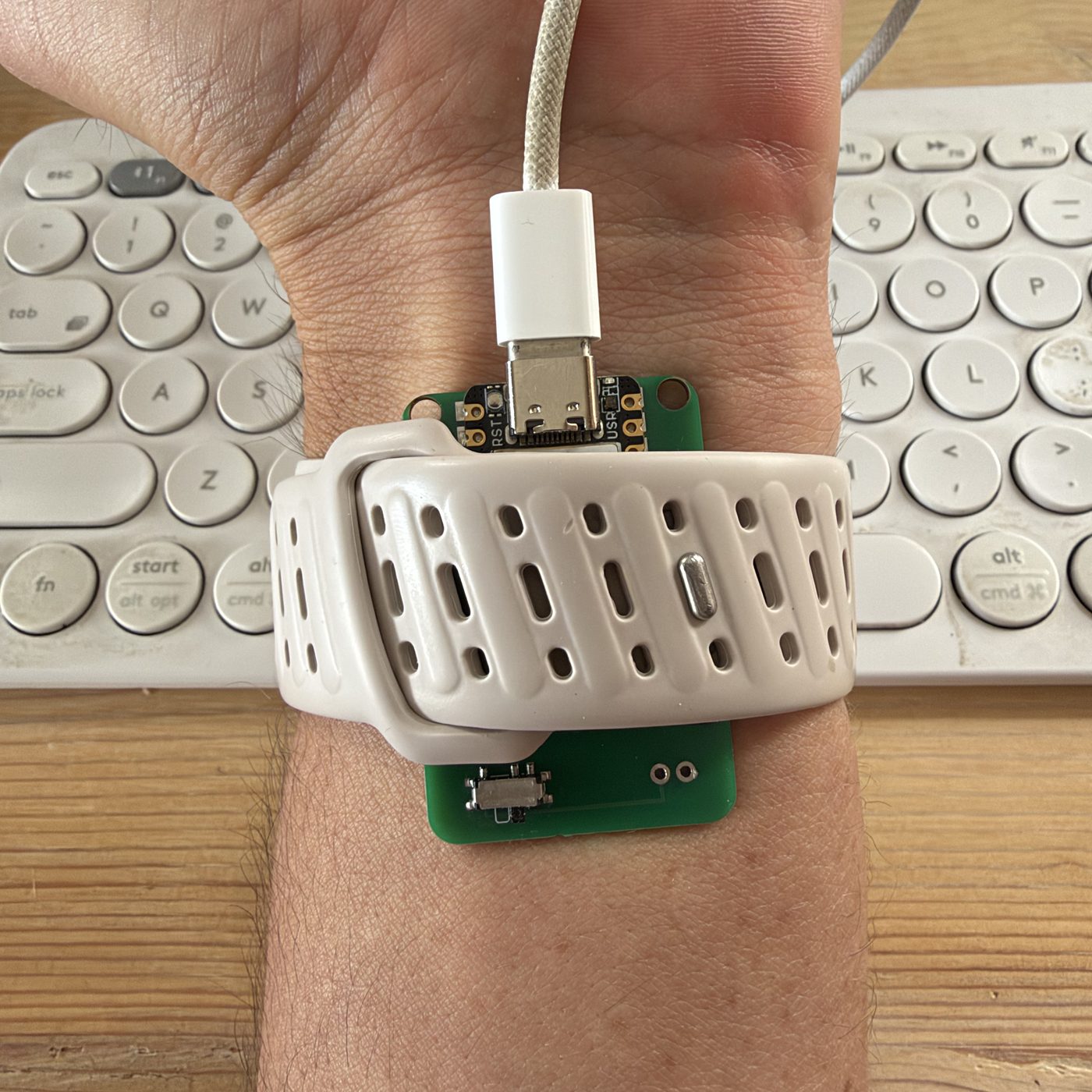A heart rate prototype designed by Tovan, running firmware Tovan wrote, strapped to a wrist with a watch band